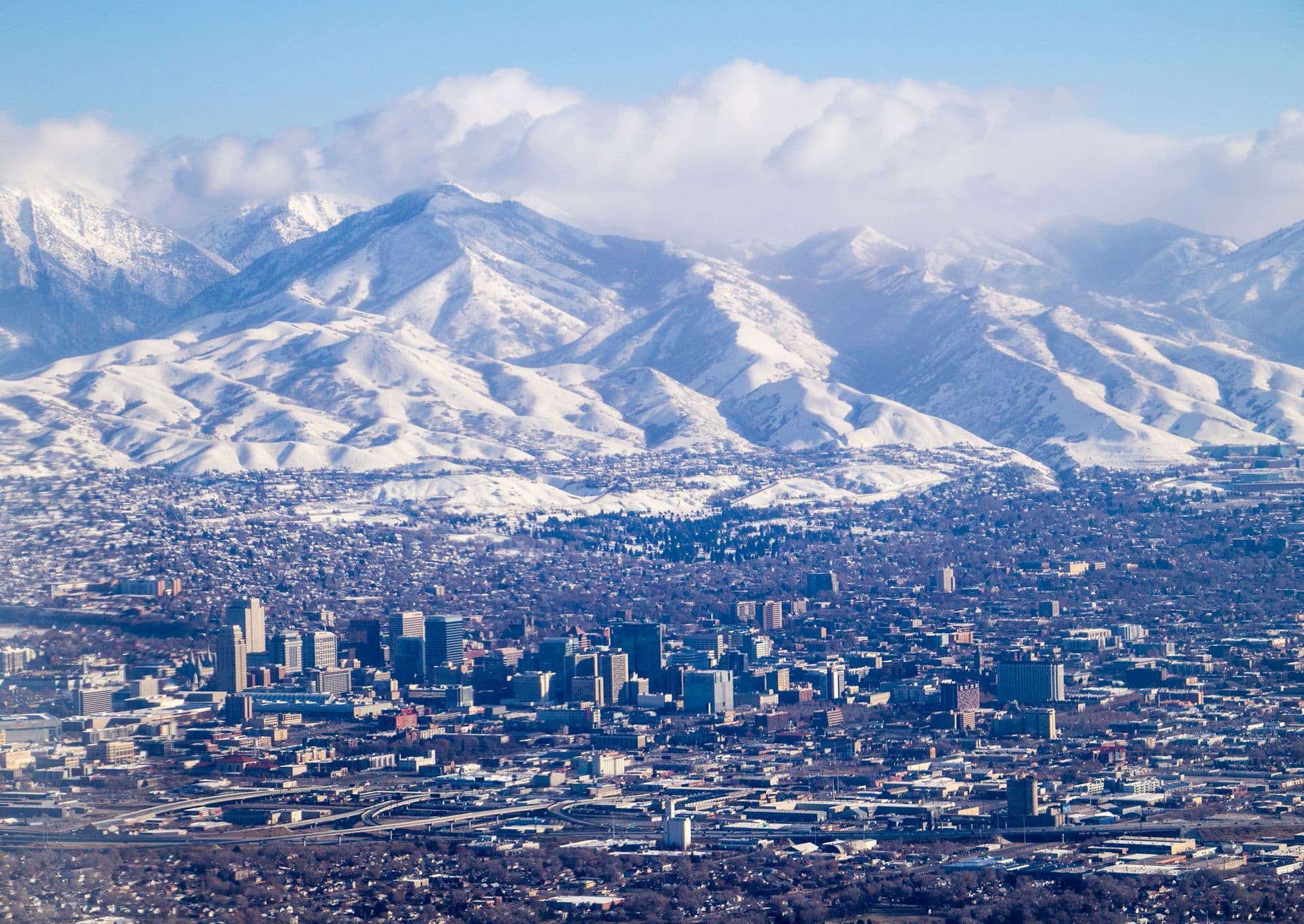 Aerial view of Salt Lake City with the snow-capped Wasatch Range behind downtown.