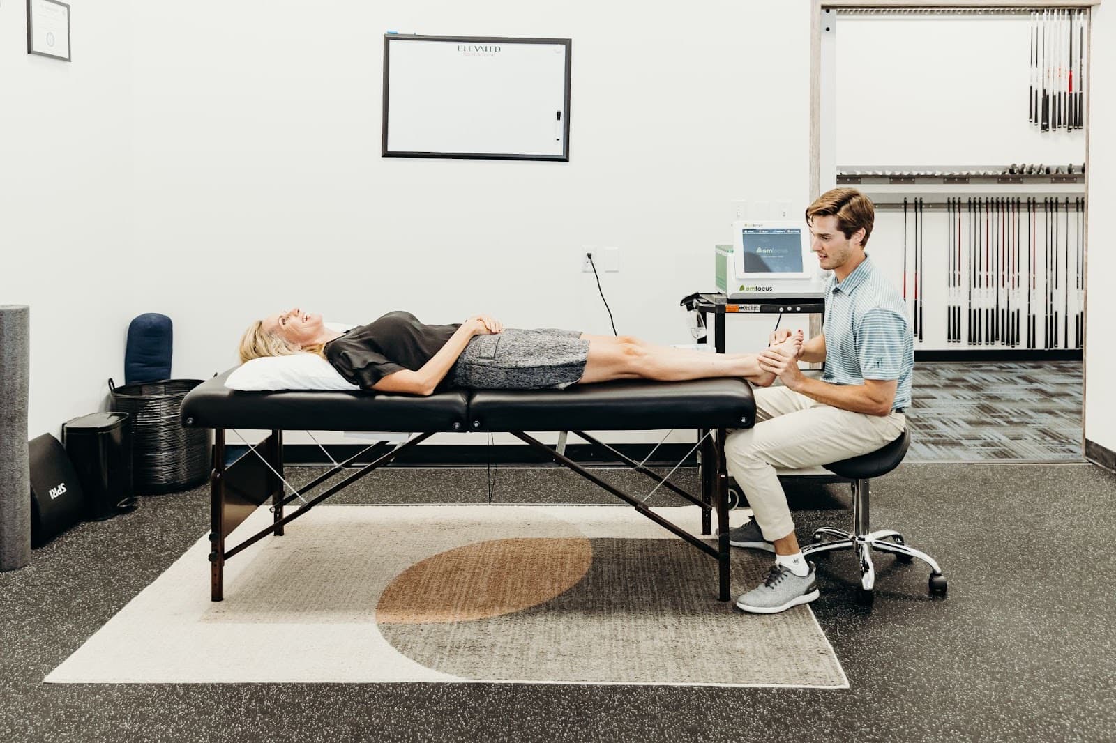 Wide view of a treatment room at Elevated Sport and Spine with a patient on the table.