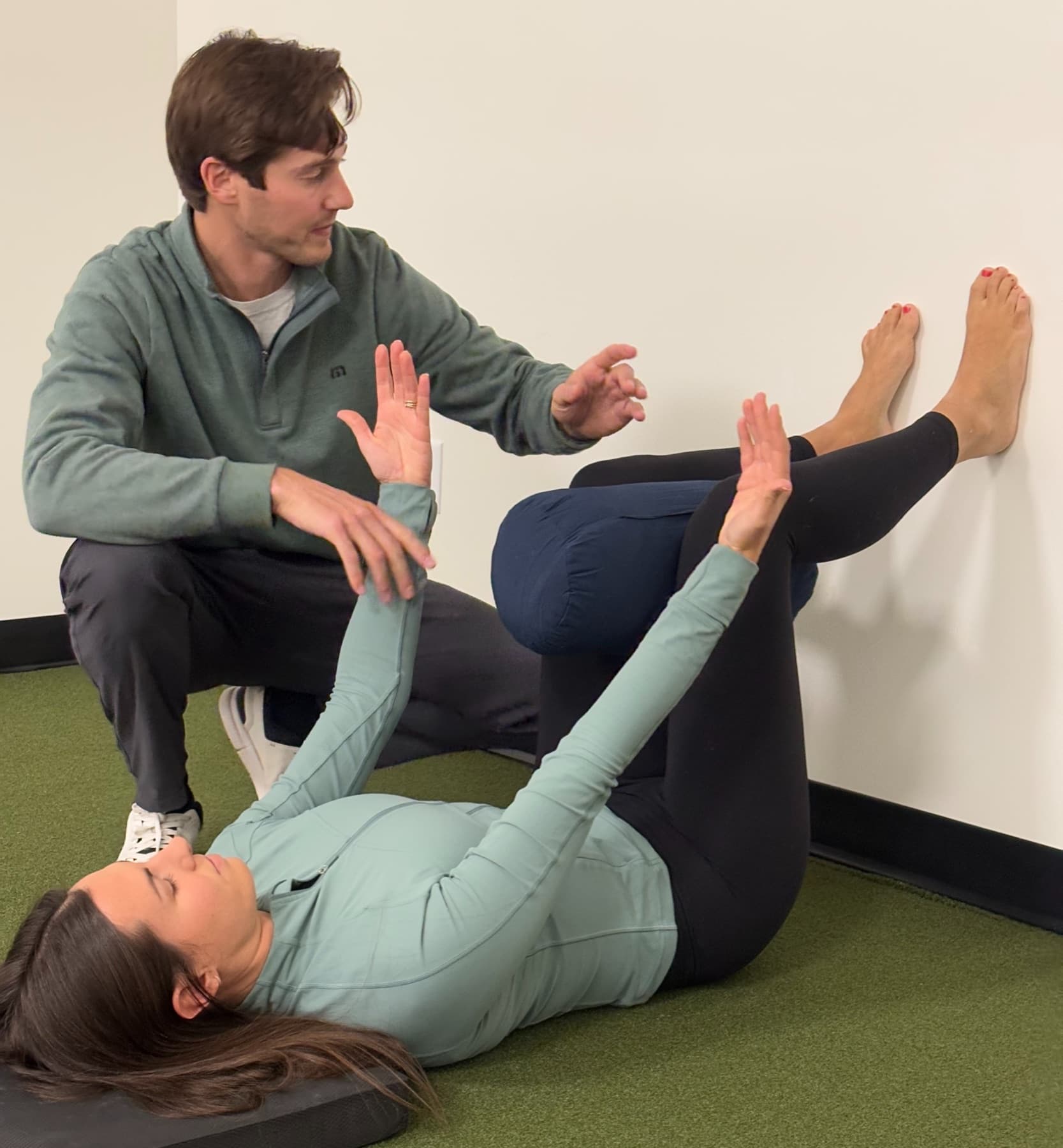 Dr. Taylor Wolf guiding a patient through an assisted mobility drill on the clinic floor.