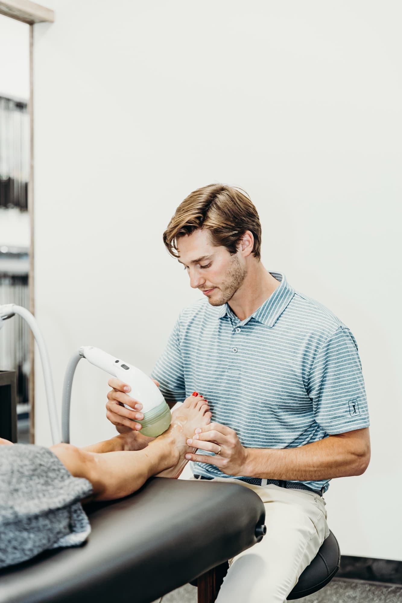 Shockwave therapy being applied to a patient's foot and ankle at Elevated Sport and Spine in Salt Lake City.